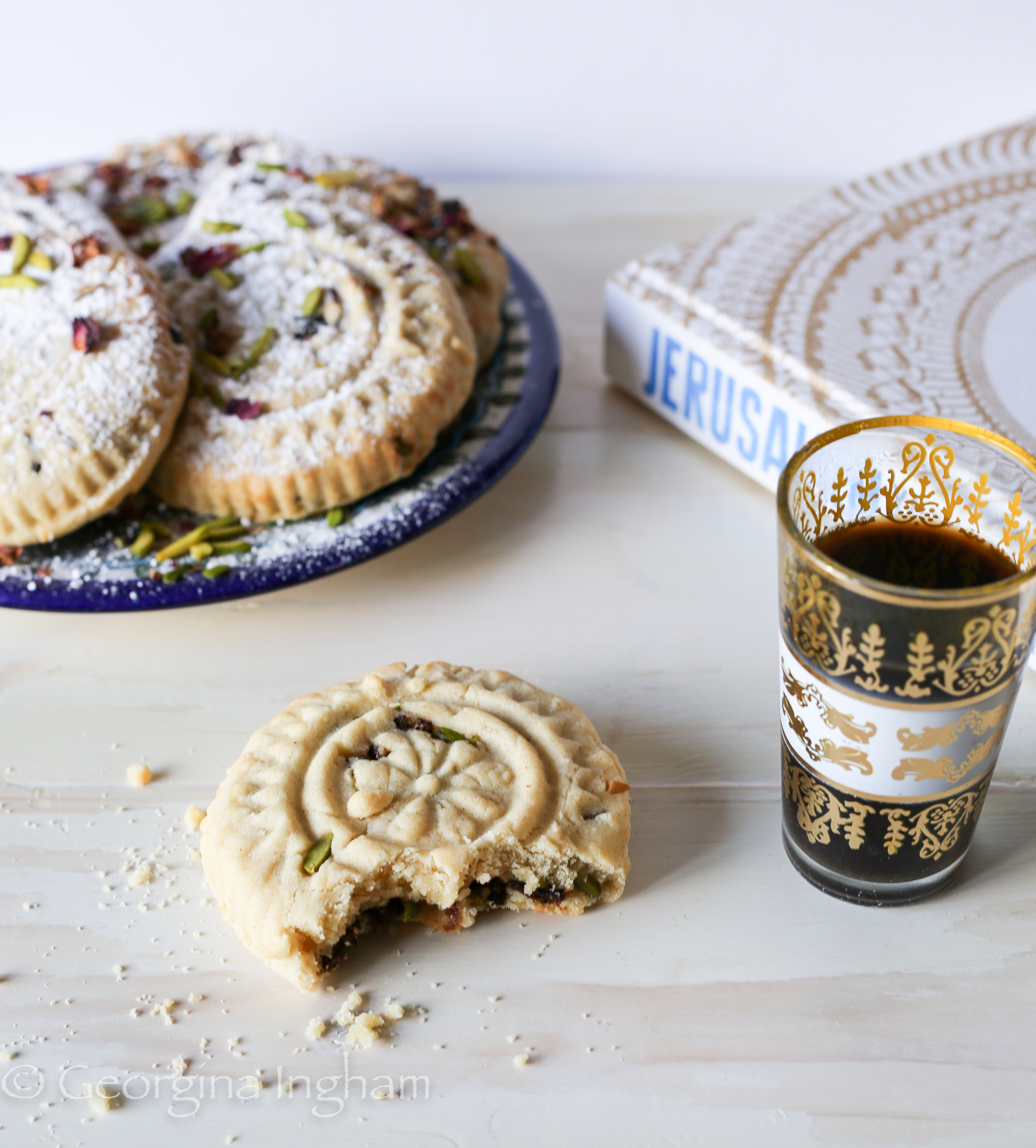 Close-up of golden Ma’amoul cookies arranged neatly, showcasing their intricate patterns and crumbly texture, ready to enjoy with coffee or tea